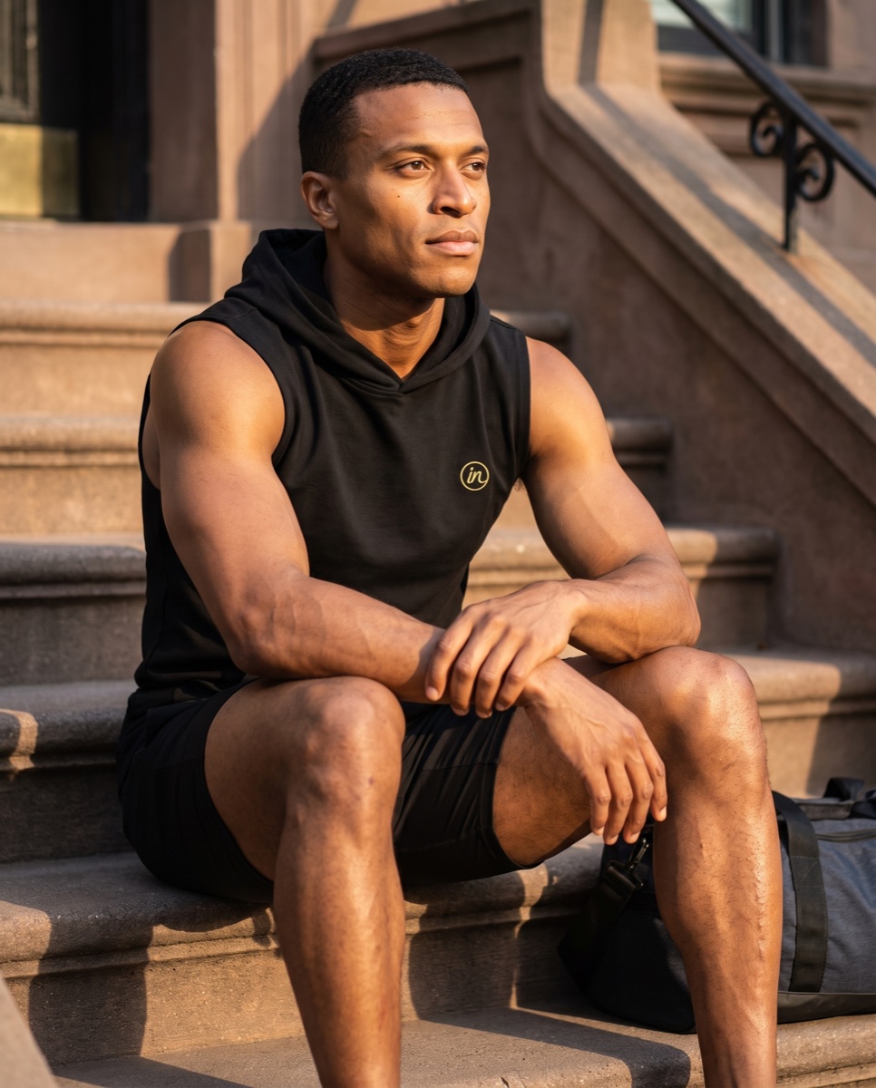 Inherit Noir sleeveless hoodie on brownstone steps